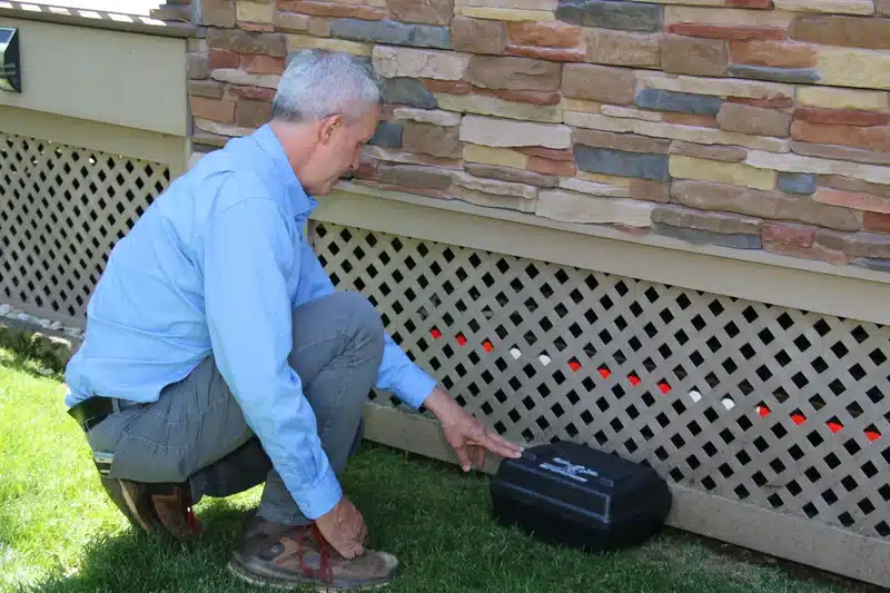 Technician placing exterior rodent control box