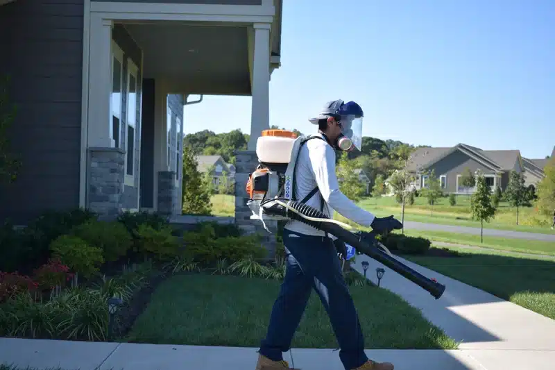 Pest control technician with backpack sprayer
